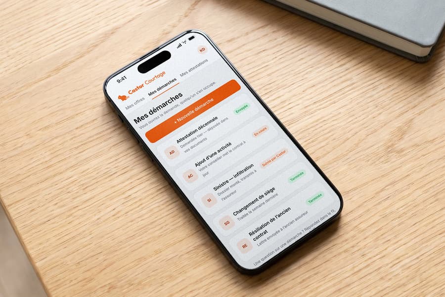 Un téléphone posé sur un bureau affiche une liste de démarches d’assurance