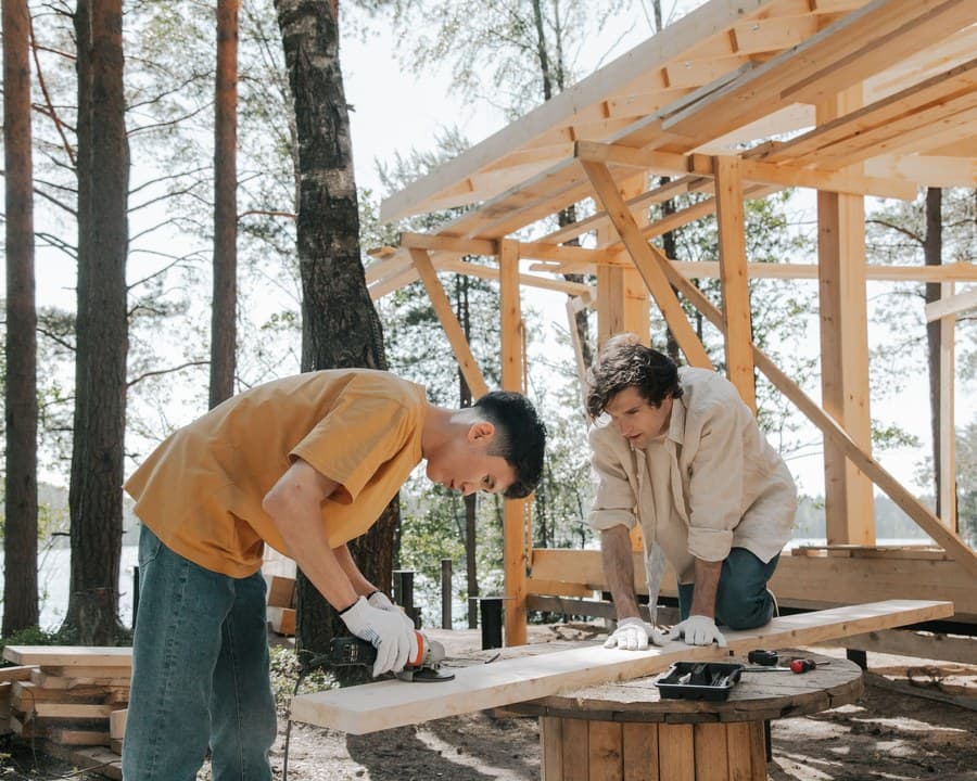 Deux charpentiers ajustent une ossature en bois