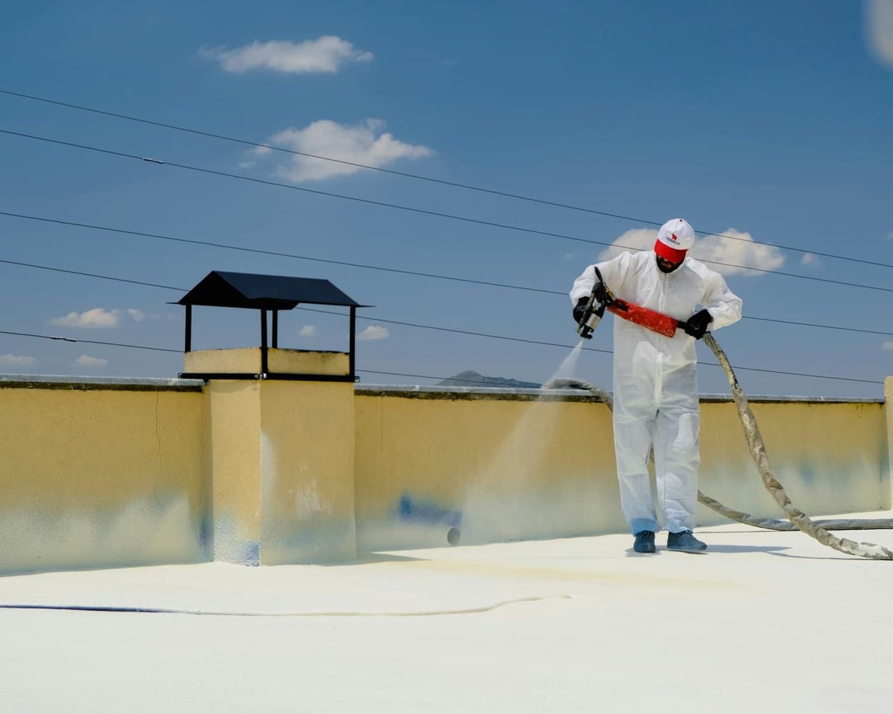 Un étancheur applique une membrane liquide sur un toit-terrasse