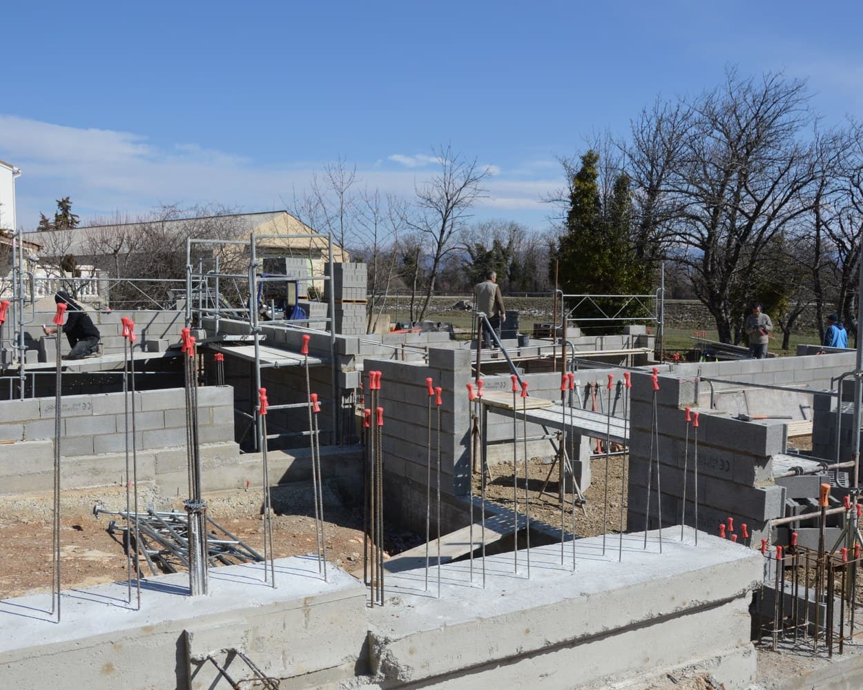 Un chantier de maison : les murs de fondation en parpaings sortent de terre
