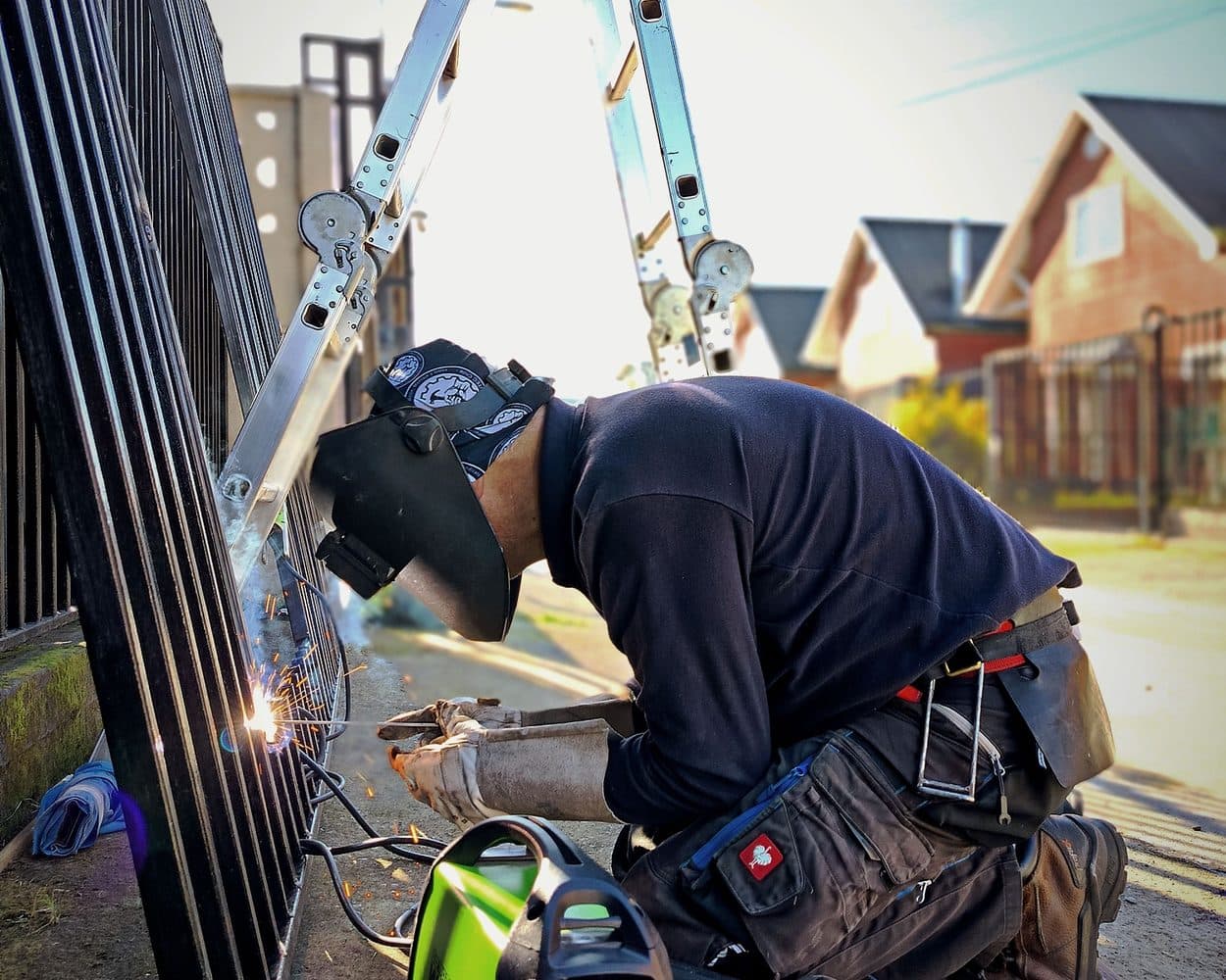Un métallier soude une clôture en acier sur chantier