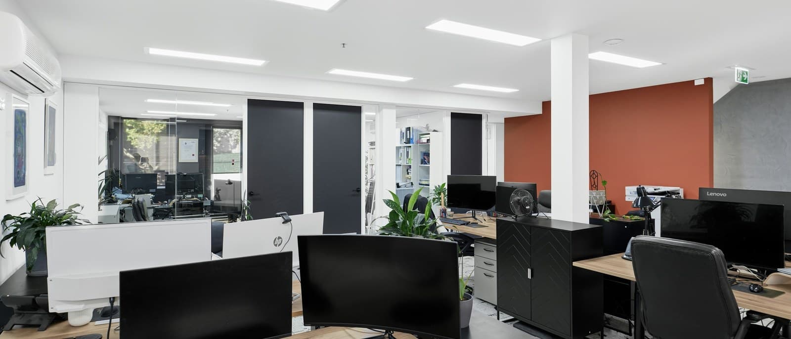Un bureau moderne, postes de travail et écrans alignés