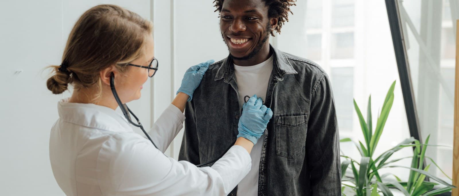 Un médecin ausculte un artisan en tenue de travail