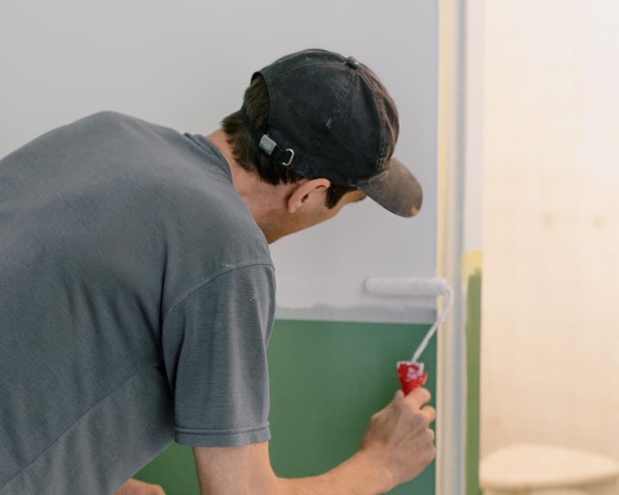 Un peintre applique une couche de peinture au rouleau