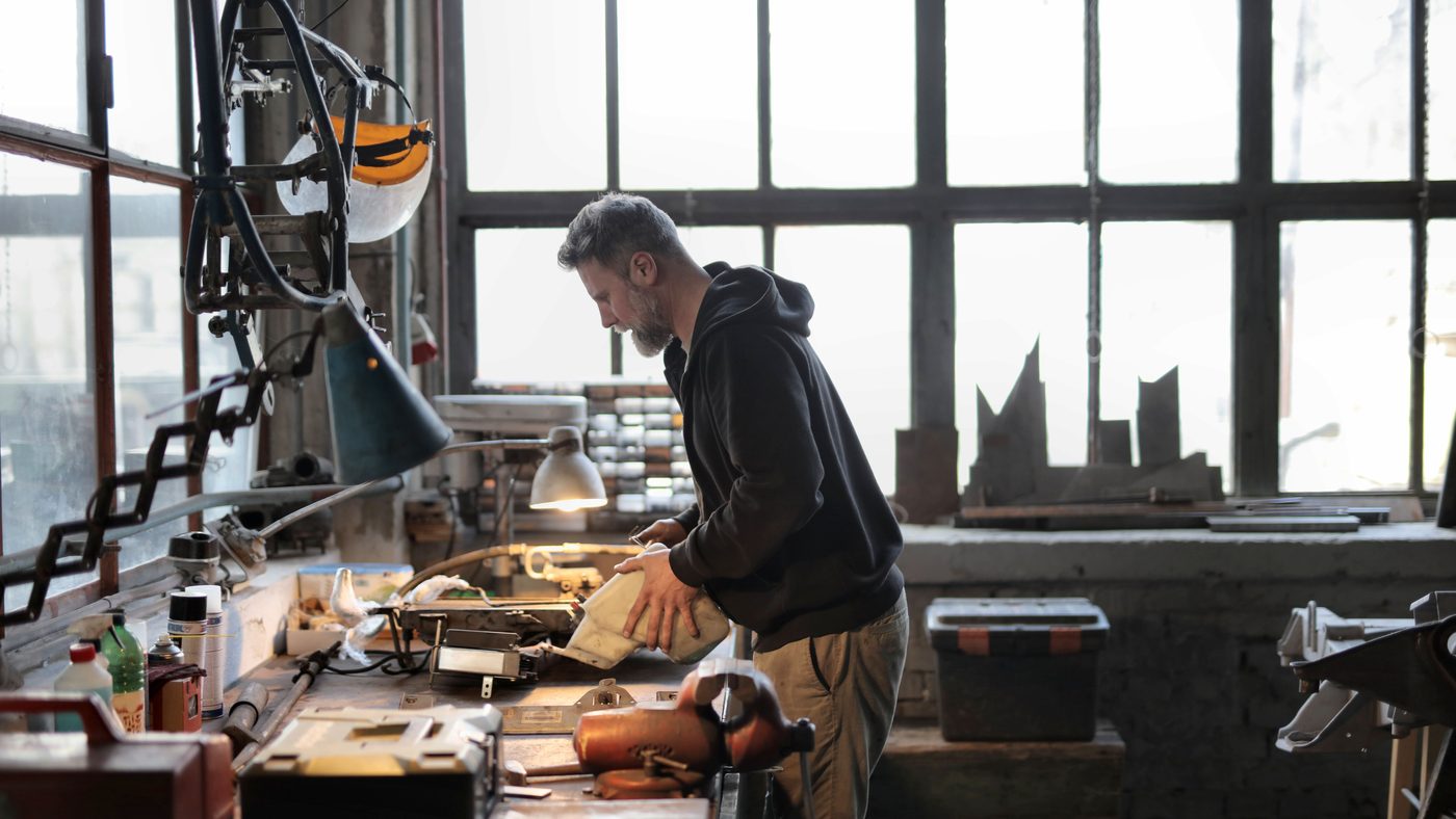Un artisan seul à son établi, dans son atelier