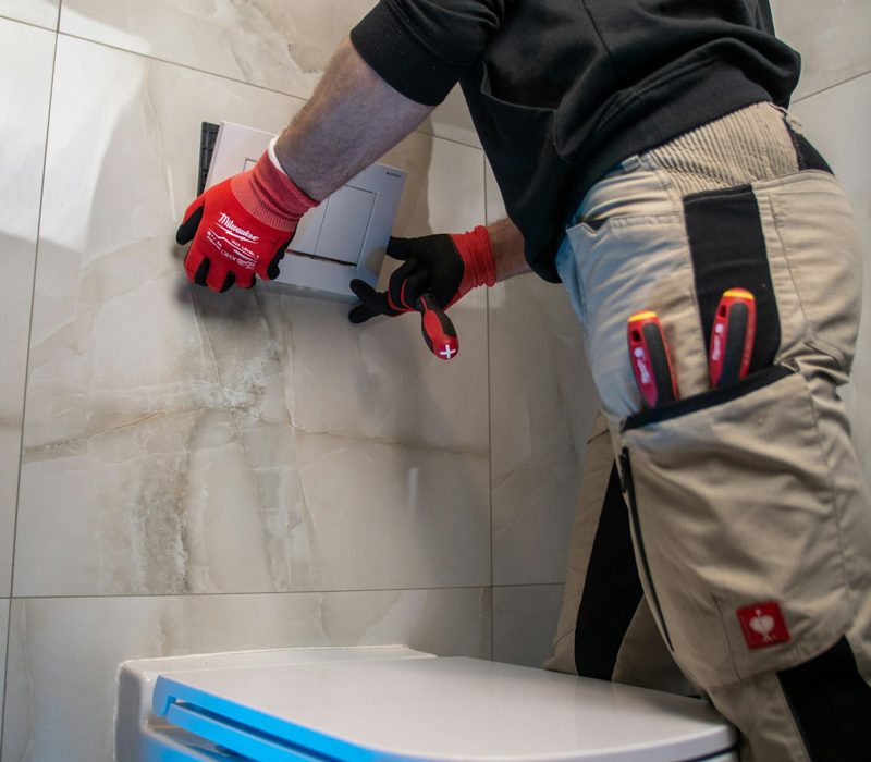 Un artisan pose un équipement dans la salle de bains d’un client