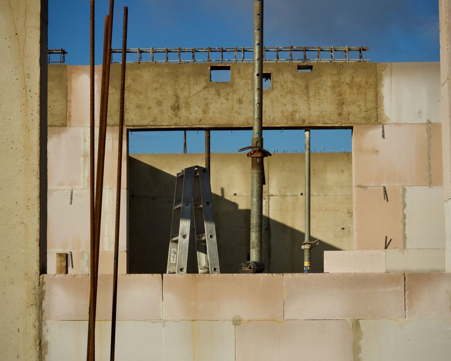 Les murs en blocs d’une maison en construction, étais et échelle au soleil